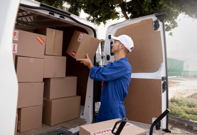 Efficient Packing: Man Loading Packed Boxes into a Van.