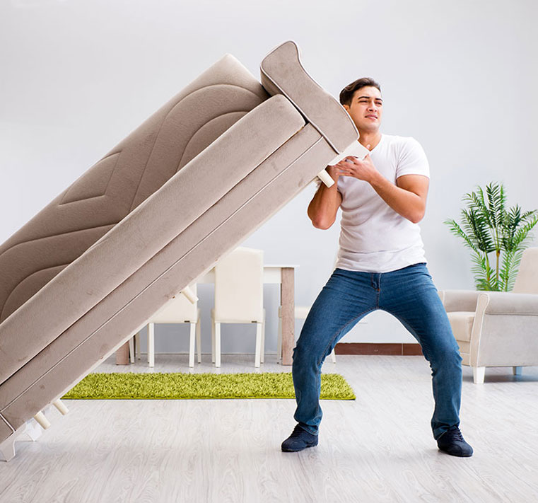Efficient Removalist: Man Carrying a Couch during Relocation.
